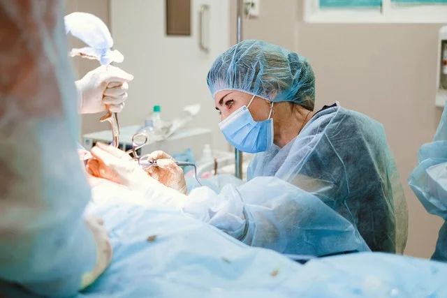 Female doctor operating a patient.